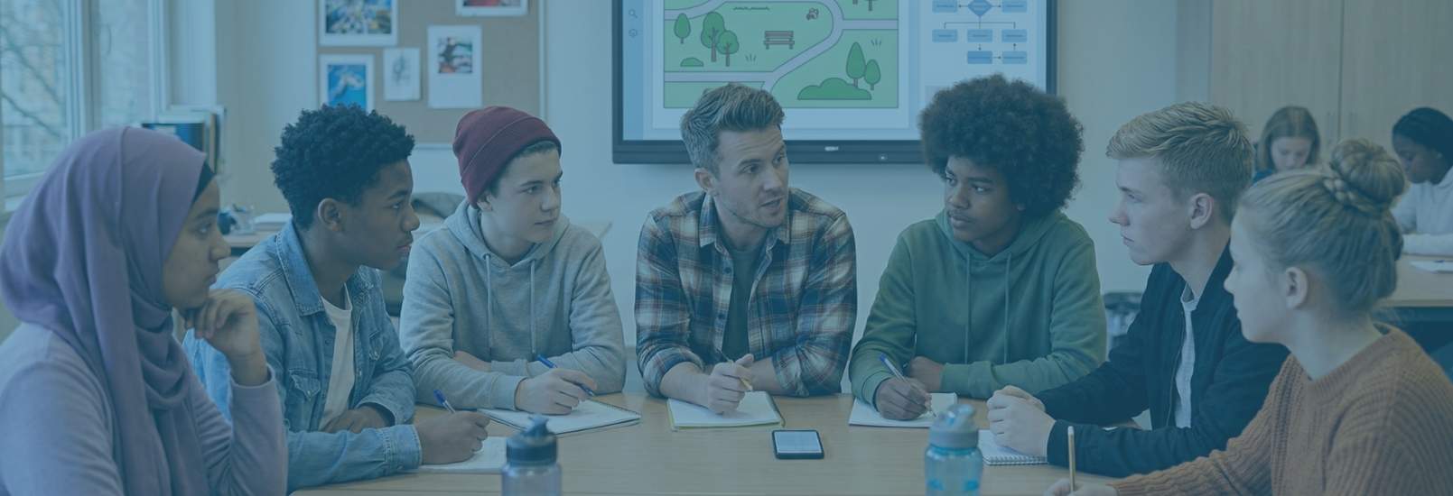 Docent begeleidt een schurend gesprek over burgerschap met middelbare scholieren in een moderne klasomgeving